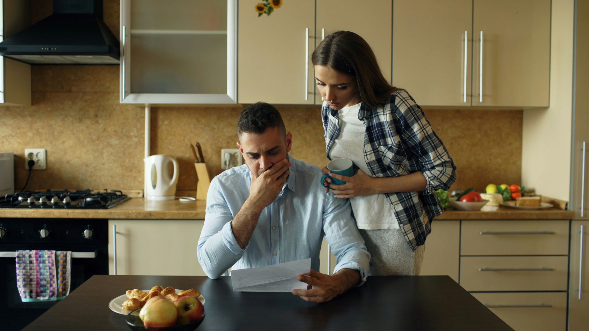 Couple looking at bill at kitchen table